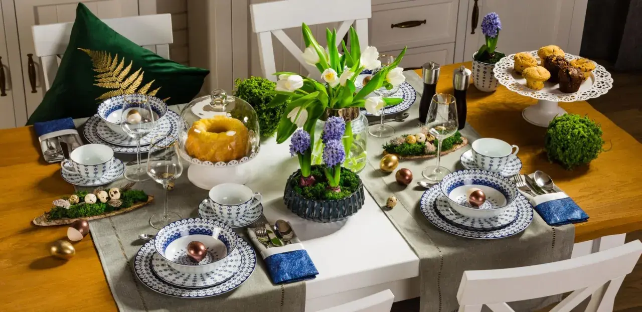 Stół wielkanocny inspiracje: białe tulipany, hiacynty, babka, babeczki, złote i miedziane jajka, porcelana z niebieskim wzorem.
