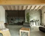 Nowoczesny salon z wygodnymi meblami i gładką, szarą podłogą epoksydową w domu.