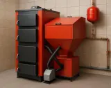 Nowoczesny piec na ekogroszek w kolorze czerwono-czarnym. Widoczne zasobnik paliwa, sterownik i elementy instalacji. Idealny do ustawienia pieca na ekogroszek tryb letni.