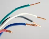 Kolorowe przewody elektryczne, każdy z odsłoniętym miedzianym rdzeniem. Widać oznaczenie prądu L na niebieskim kablu.