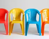 Cztery kolorowe krzesła: czerwone, żółte, niebieskie i pomarańczowe. Idealne na zewnątrz, jaka farba do plastiku na zewnątrz sprawdzi się najlepiej?
