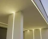 Nowoczesny budynek z subtelnym oświetleniem. Wbudowany profil LED w ścianie tworzy eleganckie linie światła, podkreślając architekturę.