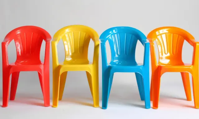 Cztery kolorowe krzesła: czerwone, żółte, niebieskie i pomarańczowe. Idealne na zewnątrz, jaka farba do plastiku na zewnątrz sprawdzi się najlepiej?