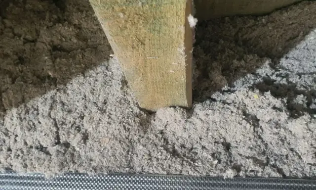 Izolacja z celulozy, która to materiał ekologiczny, wypełnia przestrzeń między drewnianymi belkami.